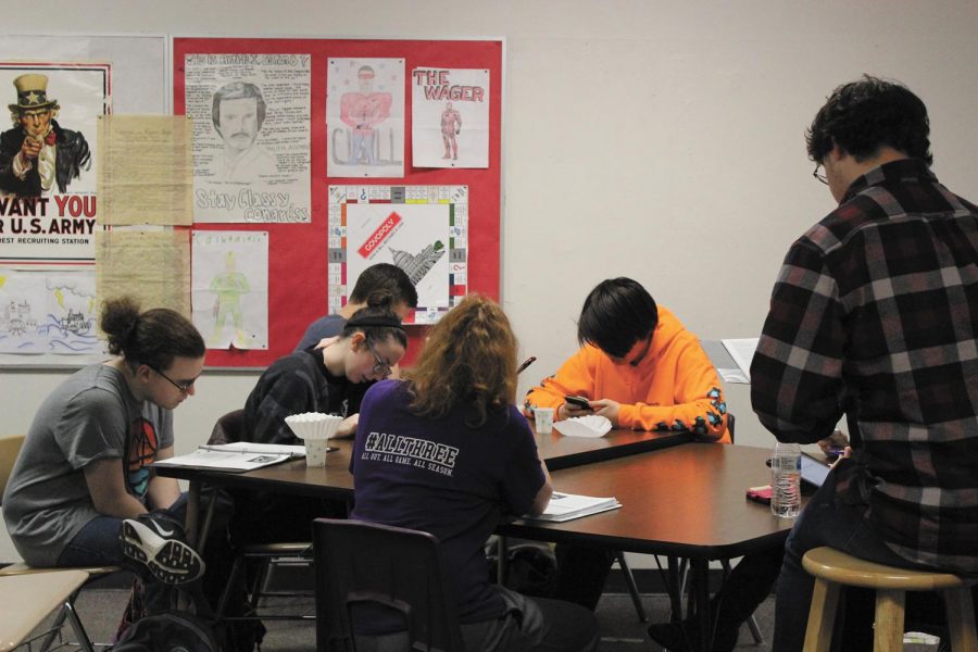 Study hard! Academic Decathlon  students study the literature resource guide to prepare for regionals at one of the after school practices. “All this preparation paid off, because we scored well enough to advance to State,” sophomore Sara Vance said.