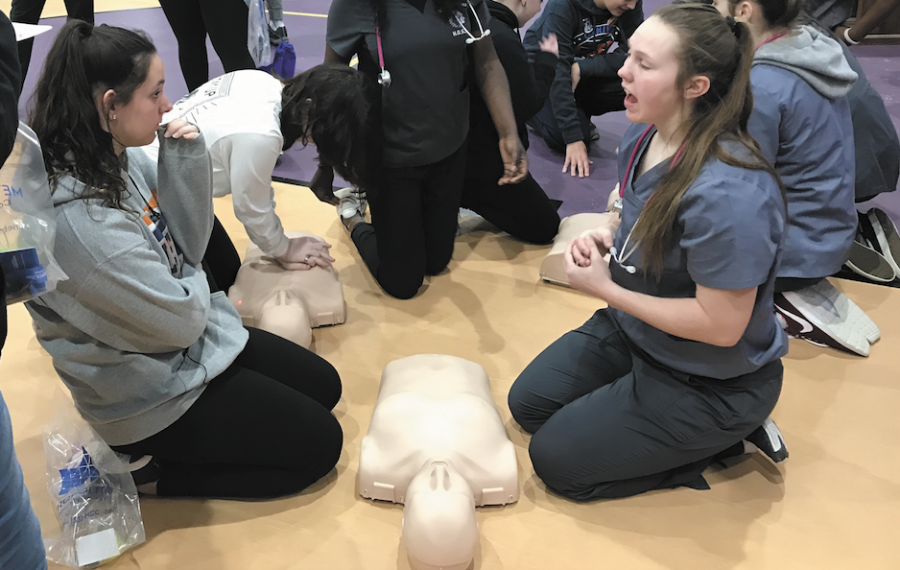 Senior Madison Luderman instructs how to perform CPR during the 8th grade Career Expo. CTE classes give students the opportunity to participate in classes that can potentially lead to their future careers. The district envisions a CTE capstone program to be house in a new building in the future. “We will work to determine the programming and space needs of each program.  At this time, we do not have an exact date for the program to begin,” Assistant Superintendent Robert Moore said. Photo by Emily Nelson 
