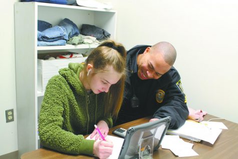 Sgt. Howard Bank assists sophomore Meadoe Anderson with her homework assignment. Banks became the new SRO at East after Officer Anthony Orsi left, and the position gives him many opportunities to interact and build relationships with students. 